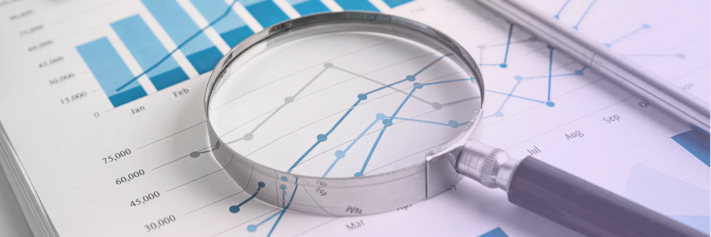 Magnifying glass placed over financial charts and graphs symbolizing data accuracy and compliance review in professional tax filing services.