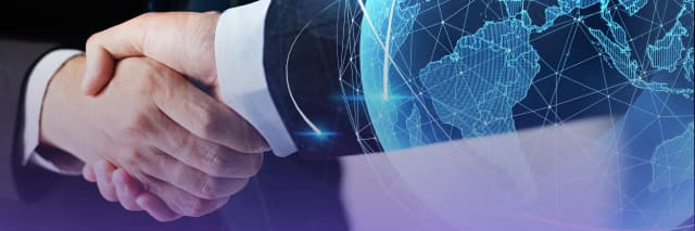 Two people shaking hands in front of a digital globe with network lines, symbolizing international cooperation and business partnership