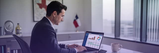 Business professional reviewing online sales tax reports and analytics dashboard on a laptop in an office.