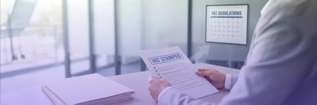 Professional reviewing VAT-stamped compliance documents in an office with VAT regulations calendar in the background