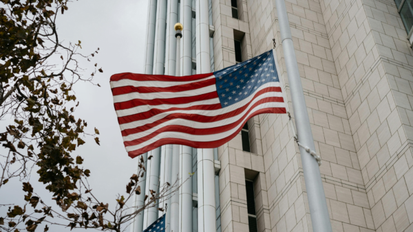 The American flag waving in front of a building.